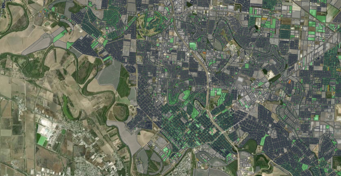 A satellite map of a city with every parcel outlined and shaded by priority score